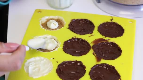 Kvinna Täcker Smält Choklad Fyllning Med Krossad Mandel Som Silikonform — Stockvideo