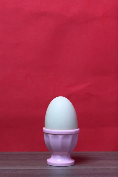 Βραστό αυγό σε ροζ ποσέ. Με φόντο το χρώμα των Κοραλλιών. — Φωτογραφία Αρχείου
