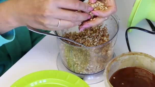 여성이 믹서기 그릇에서 재료와 땅콩을 분쇄합니다 충전물에서 굴립니다 팝케이크를 만들기 — 비디오