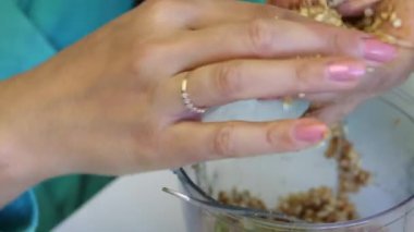 Kadın popcake doldurmak için topları rulo. Diğer malzemelerle karıştırılmış ezilmiş fıstıktan. Pistte yalanı bitti. Close.