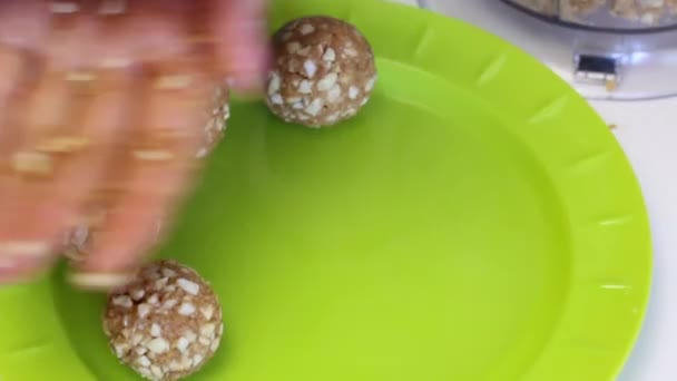 Woman Rolls Balls Filling Popcake Puts Them Plate Crushed Peanuts — Stock Video