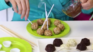 Bir kadın bir popcake kütükererer çikolata içine daldırma. Tabakta bir sonraki hazır boşluklar var...