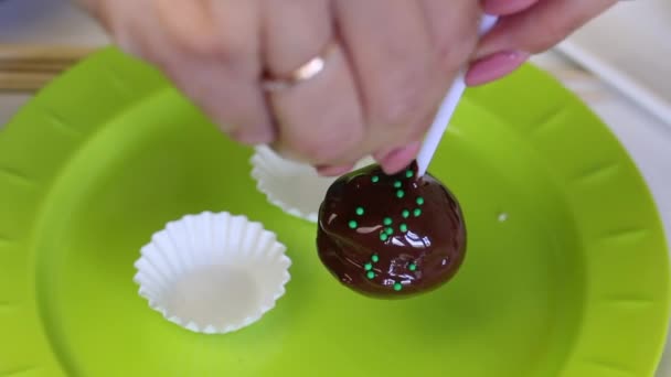 女性はケーキポップケーキブランクを飾るドレッシングで飾ります ドレッシングは溶けたチョコレートにくっつく — ストック動画