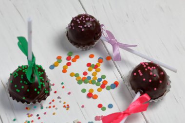 Kek örgü bir yay ile dekore açılır. Tahtaların üzerinde yatıyorlar, beyaza boyanmış. Yakındaki çok renkli dekoratif tepesi dağınık.