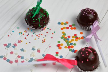 Kek örgü bir yay ile dekore açılır. Tahtaların üzerinde yatıyorlar, beyaza boyanmış. Yakındaki çok renkli dekoratif tepesi dağınık.