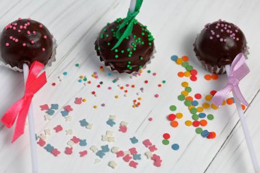 Kek örgü bir yay ile dekore açılır. Tahtaların üzerinde yatıyorlar, beyaza boyanmış. Yakındaki çok renkli dekoratif tepesi dağınık.