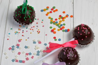 Kek örgü bir yay ile dekore açılır. Tahtaların üzerinde yatıyorlar, beyaza boyanmış. Yakındaki çok renkli dekoratif tepesi dağınık.