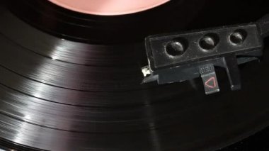 Vinil kayıt oyuncu üzerinde döner. İzler görünür, iğneile pikap parça boyunca hareket eder. Her şey tozla kaplı..