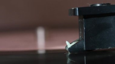 Vinil kayıt oyuncu üzerinde döner. Görünür pikap iğnesi. Baş yükselir. Her şey tozla kaplı..