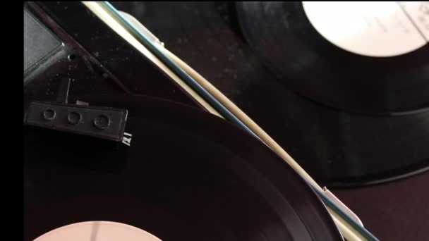 乙烯基唱片在播放器上旋转 玩家的头部沿着轨道移动 附近是乙烯基唱片 — 图库视频影像