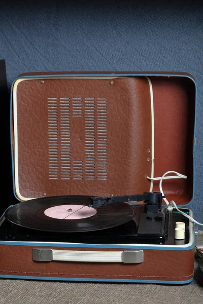 Un viejo gramófono con un disco de vinilo montado en él . — Foto de Stock
