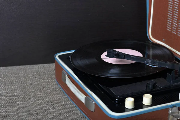 Un viejo gramófono con un disco de vinilo montado en él . —  Fotos de Stock