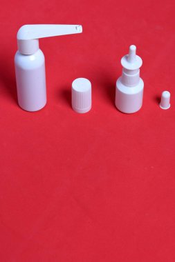 Beyaz sprey burun ve ağız spreyi. Mercan renginin arka planına karşı. Yukarıdan görüntüle.