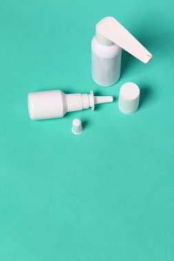 Beyaz sprey burun ve ağız spreyi. Nane renginin arka planına karşı. Yukarıdan görüntüle.