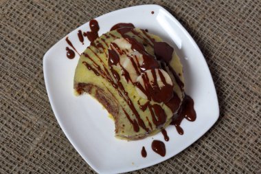 Kaba keten kumaş. Muzlu magkekli bir tabağı var..