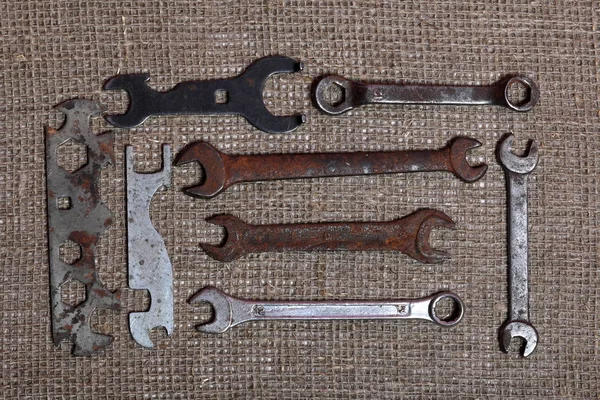 Wrenches for different sizes. Worn and covered with corrosion. They lie on a rough linen cloth.