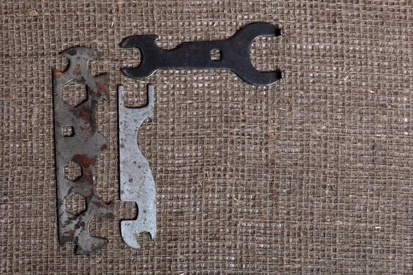 Wrenches for different sizes. Worn and covered with corrosion. They lie on a rough linen cloth.