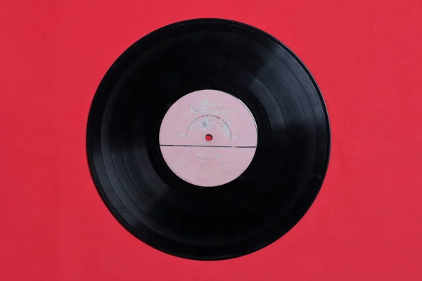 Antiguo disco de vinilo. Desgastado y sucio. Se encuentran en la superficie de color coral . — Foto de Stock