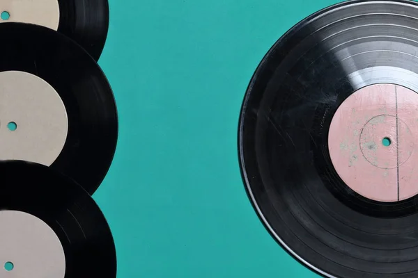 Viejos discos de vinilo. Desgastado y sucio. Se encuentran en la superficie de color menta . — Foto de Stock