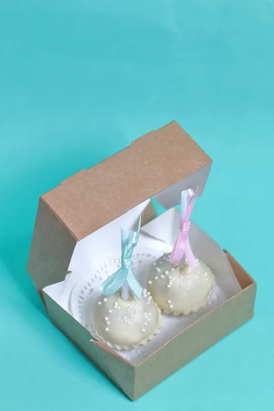 Pastel pops decorado con un lazo de trenza, embalado en una caja de regalo. Sobre el fondo del color menta . — Foto de Stock
