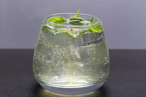 Bebida refrescante con burbujas de gas. Nalit en un vaso transparente. Echaba hielo picado. Decorado con hojas de menta . —  Fotos de Stock