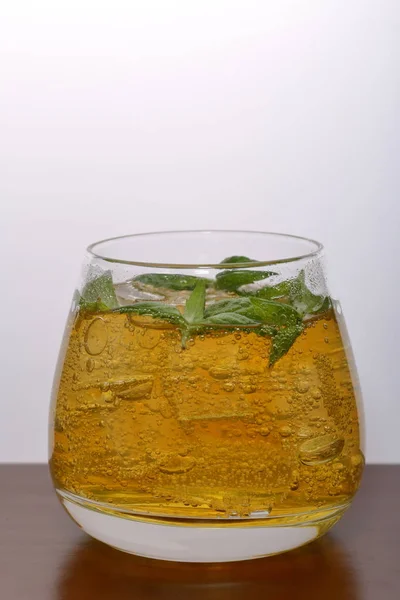 Δροσιστικό ποτό με φυσαλίδες αερίου. Να το αφήσω σε διαφανές γυαλί. Είχε θρυμματισμένο πάγο. Διακοσμημένο με φύλλα δυόσμου. — Φωτογραφία Αρχείου