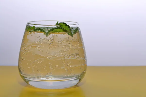 Bebida refrescante con burbujas de gas. Nalit en un vaso transparente. Echaba hielo picado. Decorado con hojas de menta . —  Fotos de Stock