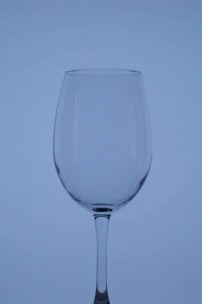 Wine glass on a long stem. In back blue color. — Stock Photo, Image
