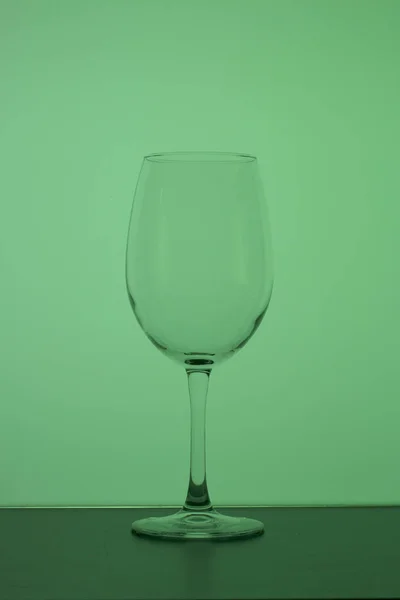 Weinglas auf einem langen Bein. hinten grün. — Stockfoto