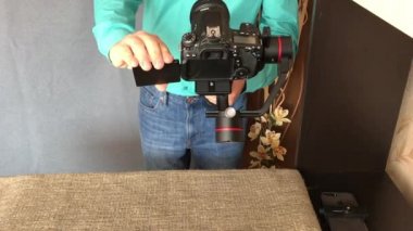 Minsk, Minskaya, Beyaz Rusya 11 Temmuz 2019, Bir blogcu internette kendi kanalı için elektronik üç eksenli bir sabitleyici bir video incelemesi çekiyor. Selfie modunun çalışmasını gösterir..