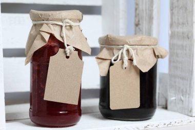 Reçel kavanozları, kağıt ile kaplıdır ve ikiyle bağlanmış. Dize asmak Craft etiketleri. Tahta bir kutuda dur.