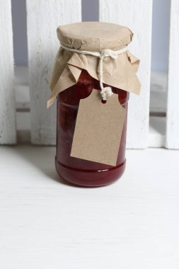 Reçel kavanozları, kağıt ile kaplıdır ve ikiyle bağlanmış. Dize asmak Craft etiketleri. Ahşap tahtaları arka planda.