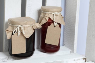 Reçel kavanozları, kağıt ile kaplıdır ve ikiyle bağlanmış. Dize asmak Craft etiketleri. Tahta bir kutuda dur.