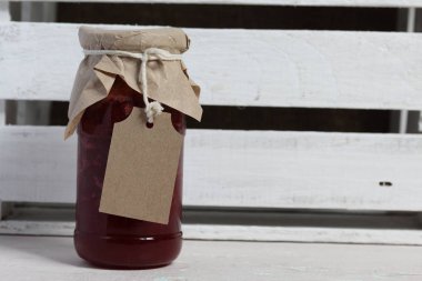 Reçel kavanozları, kağıt ile kaplıdır ve ikiyle bağlanmış. Dize asmak Craft etiketleri. Ahşap tahtaları arka planda.