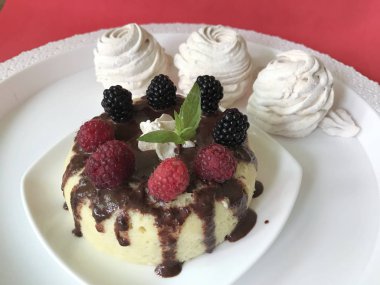 Muz Magcake. Çikolata, ahududu, böğürtlen ve nane yaprakları ile dekore edilmiş.