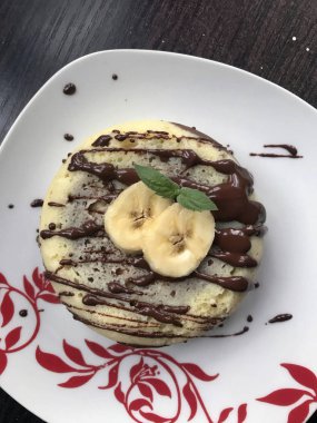 Muz Magcake. Çikolata, muz dilimleri ve nane ile dekore edilmiş.