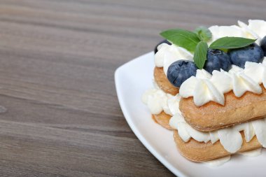 İtalyan savoyardi kurabiye ve krema yapılmış kek. Yaban mersini ve nane yaprakları ile dekore.