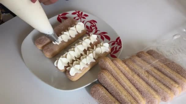 Donna Rose Crema Sui Biscotti Savoiardi Utilizzando Sacchetto Pasticceria — Video Stock