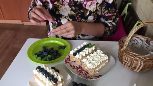 Een Vrouw Versiert Een Taart Met Muntblaadjes Lagen Savoiardi Koekjes — Stockvideo