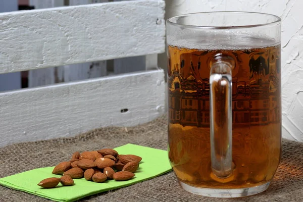 A glass of foamy beer and almonds on a napkin. Beer Festival. — Stock Photo, Image