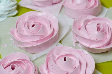 Taze yapılmış marshmallowlar masanın yüzeyinde uzanır. Dengeleniyor.