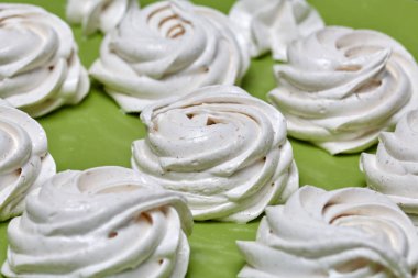 Taze yapılmış marshmallowlar masanın yüzeyinde uzanır. Dengeleniyor.