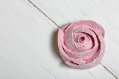 Pudra şekeri bir çiçek şeklinde pembe marshmallows. Beyaz boyalı tahtalar üzerinde yatıyor.