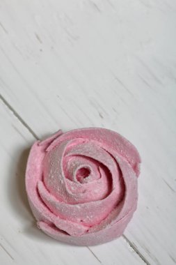 Pudra şekeri bir çiçek şeklinde pembe marshmallows. Beyaz boyalı tahtalar üzerinde yatıyor.