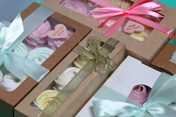 Malvaviscos de diferentes colores en cajas de regalo. Cajas atadas con una cinta de color atada a un lazo. Vista desde arriba . — Foto de Stock