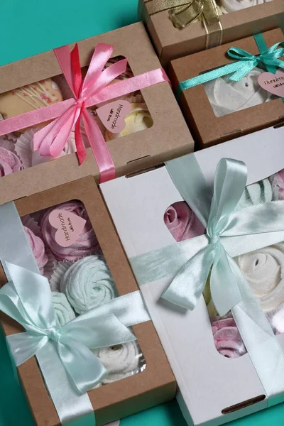Malvaviscos de diferentes colores en cajas de regalo. Cajas atadas con una cinta de color atada a un lazo. Vista desde arriba . — Foto de Stock
