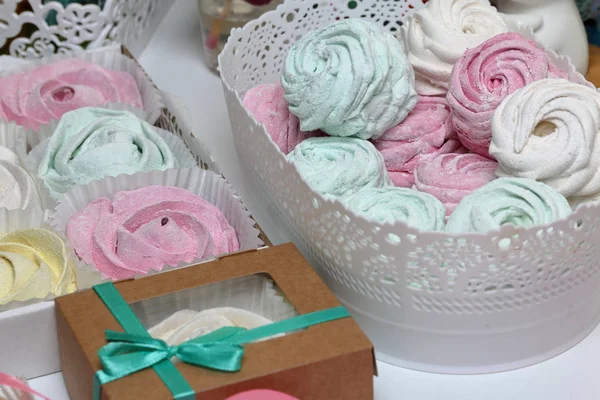 Marshmallow di diversi colori e forme. Alcuni a forma di fiore. Impilato in confezioni regalo. Nelle vicinanze ci sono nastri colorati per spogliatoi . — Foto Stock