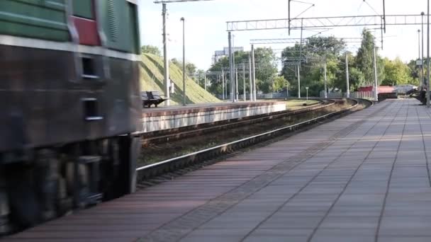 Passagerare elektriskt tåg går på räls längs plattformen. — Stockvideo