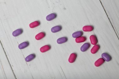 Nefes tazelemek için dragee. Farklı renkte. Sıraya dizin. Mercan arka planında.