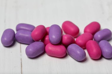 Nefes tazelemek için dragee. Farklı renkte. Beyaz bir yüzey üzerinde yatan.